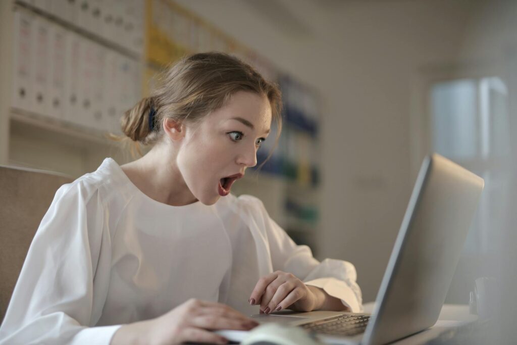 Woman in White Long Sleeve Shirt Using Silver Laptop Computer